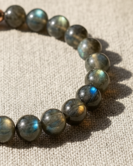 Beaded bracelet with labradorite stones on a textured fabric background
